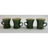 Four pottery mugs, in a mid green glaze with musta