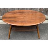 An Ercol beech and elm oval coffee table, with mag