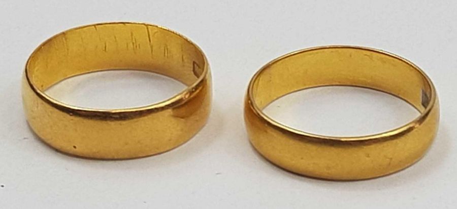 A 22ct gold wedding band, 5.7mm wide, finger size N 1/2 and another 2