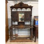 An early 20th century carved oak hall stand, with