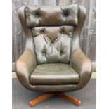 A1970s swivel egg chair, upholstered in green viny