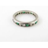 A diamond and emerald eternity ring, the white mou