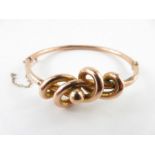 An Edwardian lovers knot hinged bangle, tagged ‘9c