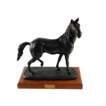 A large bronzed model of a horse, standing on a re