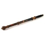 A painted and carved wooden baton bearing the mott