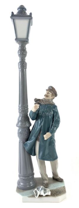 A large Lladro figure standing under a lamp post,