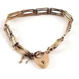 A fancy link gate bracelet with heart padlock and