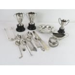 A collection of silver to include tea spoons, tong