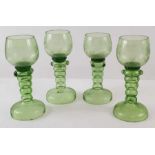 A set of four green glass goblets, the bowls with