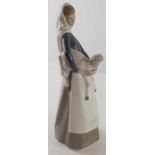 A Lladro figure of a girl holding a lamb, 17.5cm h