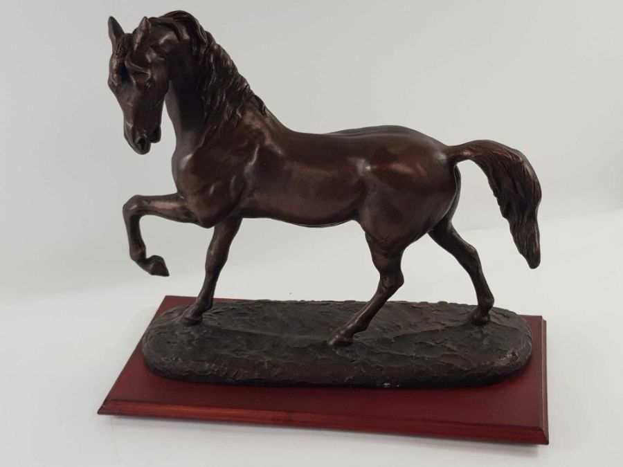 A large bronzed model of a galloping horse, standi