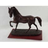 A large bronzed model of a galloping horse, standi