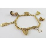 A curb link charm bracelet stamped '375', with hea