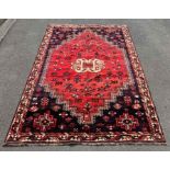 A 20th century rug, in a red and purple ground, pr