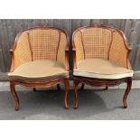 A pair of cane and mahogany open armchairs