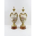 A near pair of two handled vases and covers in the