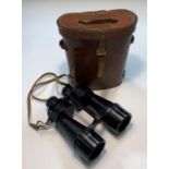 A pair of leather cased military binoculars dated 1944 with
