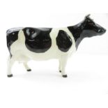 A Beswick figure of a Fresian cow, marked to the