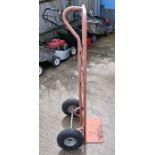 A tall pink sack truck with pneumatic tyres