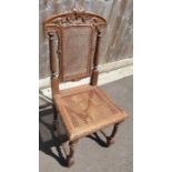 An early 20th century oak dining chair, with cane