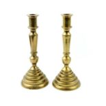 A pair of brass cast candlestick, each standing on