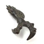 A bronze model of a birds claw, with some feathers