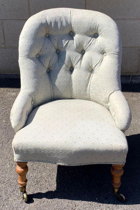 A Victorian button back armchair, with a spoon sh