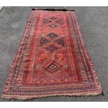 A 20th century decorative middle eastern rug, on a red