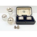 A cased pair of silver napkin rings with engine tu