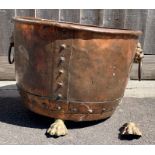 A Victorian copper log bin, standing on claw feet