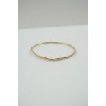 A 9ct gold solid bangle, with facetted design, 6.5