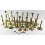 A large collection of brass candlesticks