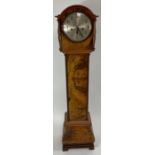 A 20th century grandmother clock, standing in a wa