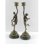 A pair of bronze candlesticks in the form of a mal