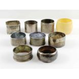 Seven silver napkin rings, all of varying design,