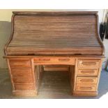 An early 20th century bleached oak roll top desk,