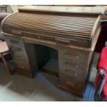 An early 20th century oak roll top desk, set with