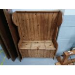 A 20th century panelled back pine settle, with a l