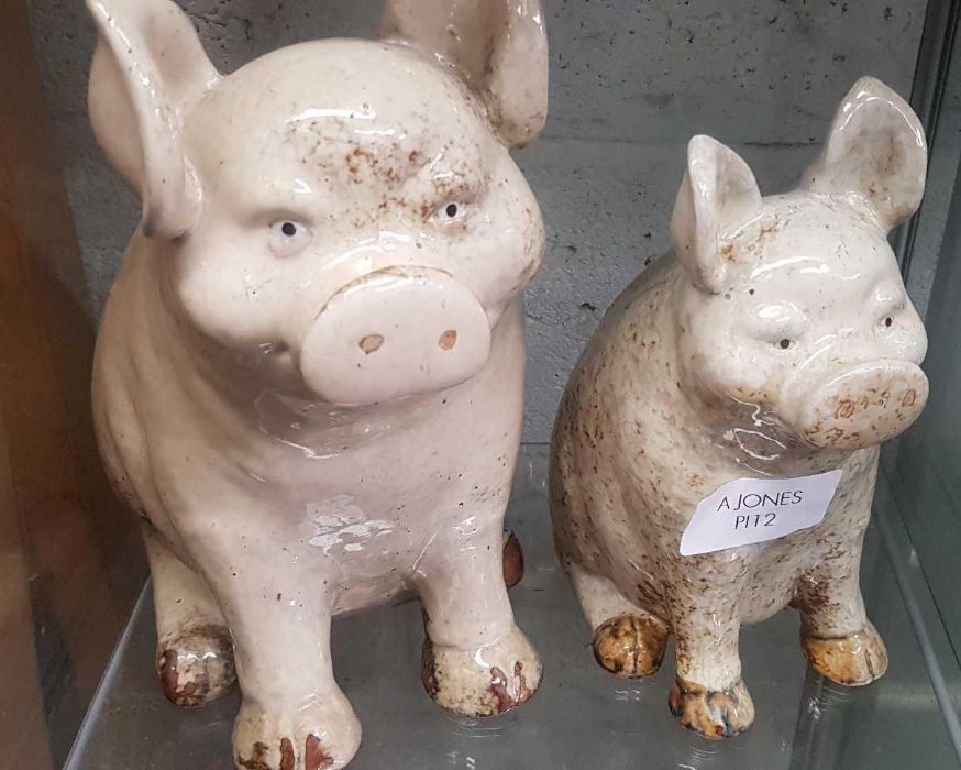 2 glazed stoneware seated pigs