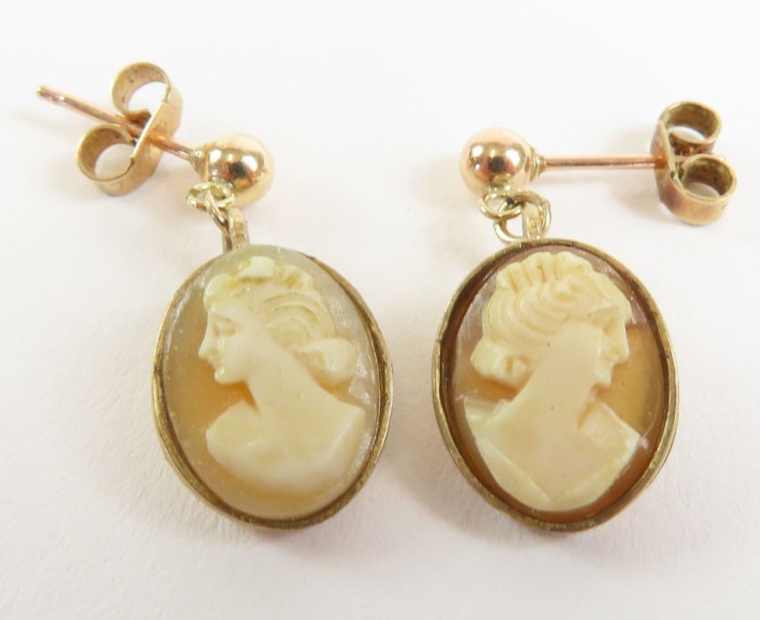 A pair of oval cameo drop earrings, each shell wit