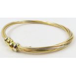 A two colour gold twisted torque bangle, marked '7