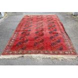 A 20th century Afghan rug, on a red ground, 375cm