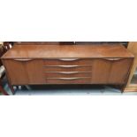 A mid century teak sideboard, four long drawers an