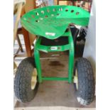 A gardeners four wheeled green sit on trolley