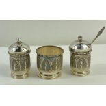 A Middle Eastern white metal cruet set, profusely