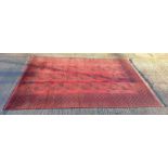 A 20th century Bokhara carpet, on red ground, 300c
