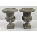 A pair of cast iron urns, each with reeded decorat
