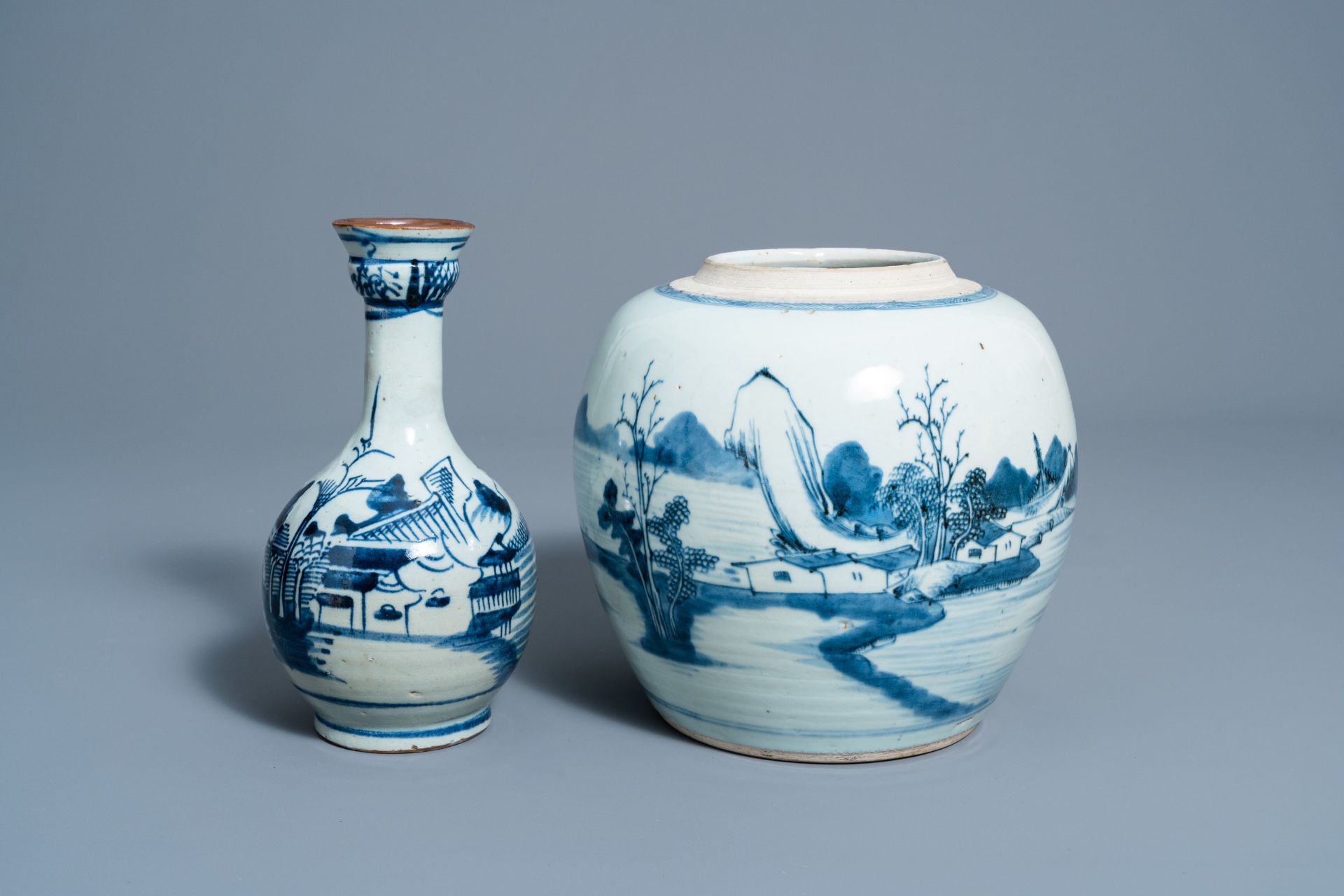 A Chinese blue and white ginger jar and a vase with a river landscape, 19th C.