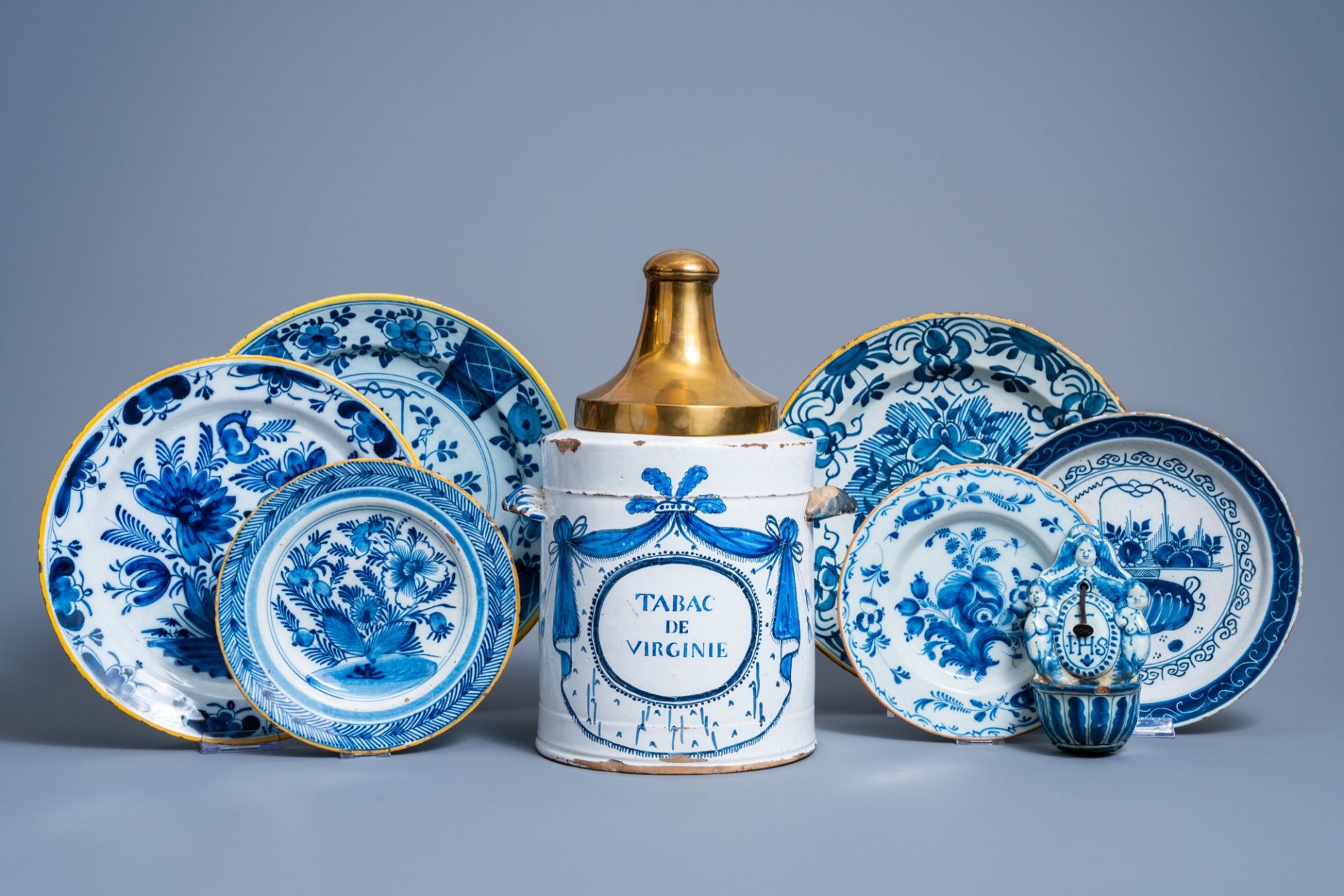 A Brussels blue and white tobacco jar, six Dutch Delft plates with floral design and a holy water fo