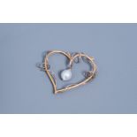 An 18 carat white and yellow heart-shaped pendant set with a diamond and a white South Sea pearl, 20